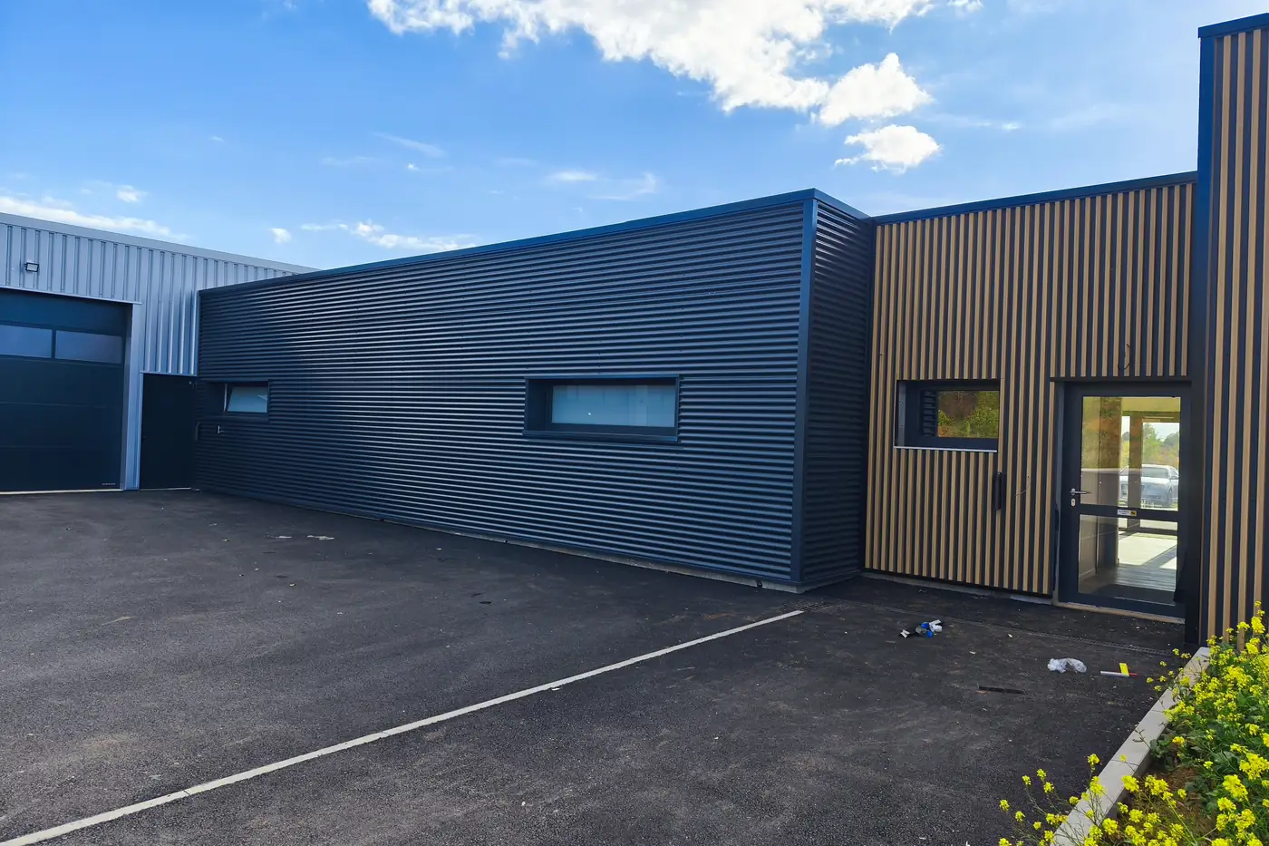 Bâtiment terminé en bardage anthracite et bois